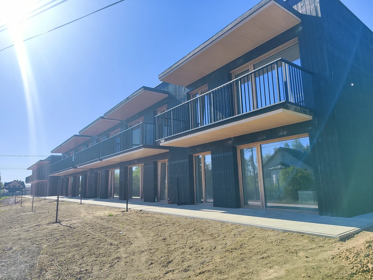 Szereg budynk&oacute;w BlackWood w Krasnem z zamontowaną stolarką i balustradami